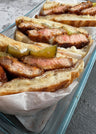 Seared pork loin chops with pink centers served on bread with pickled peppers.