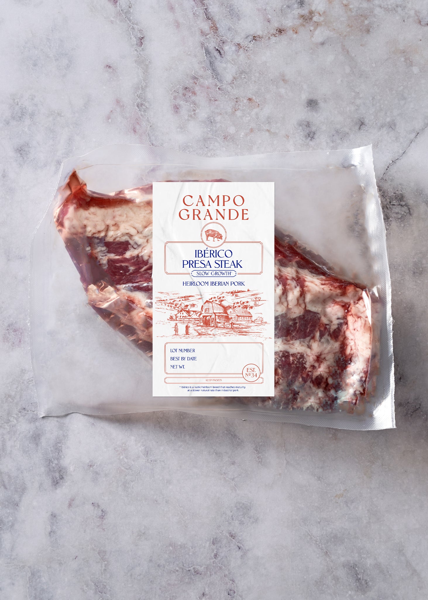 Vacuum-sealed Ibérico presa steak with Campo Grande label on marble background.