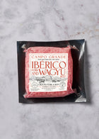 Ground pork and beef blend in black vacuum-sealed packaging with white label on marble surface.