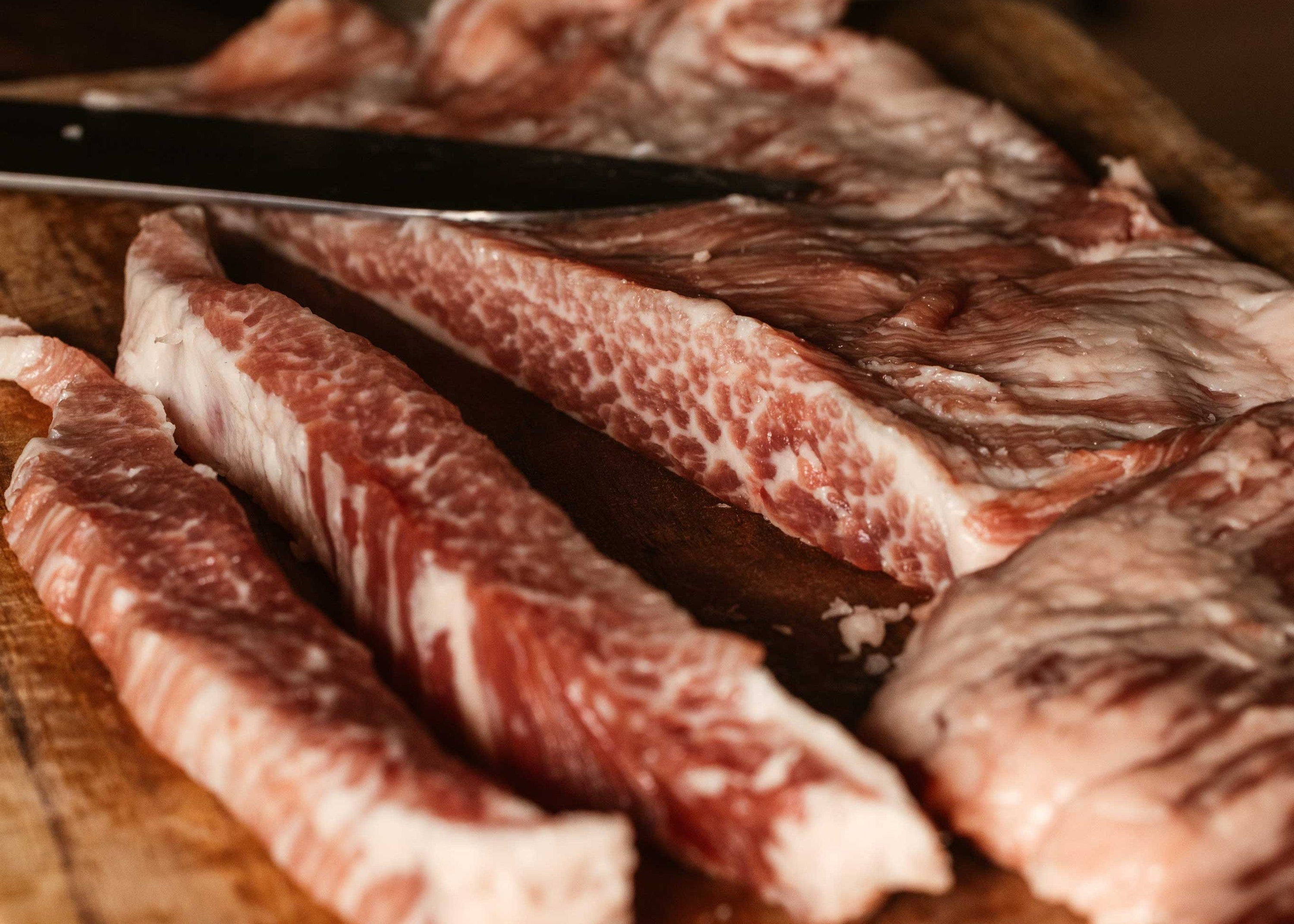 Ibérico pork cuts sizzling on the grill with smoke and fire