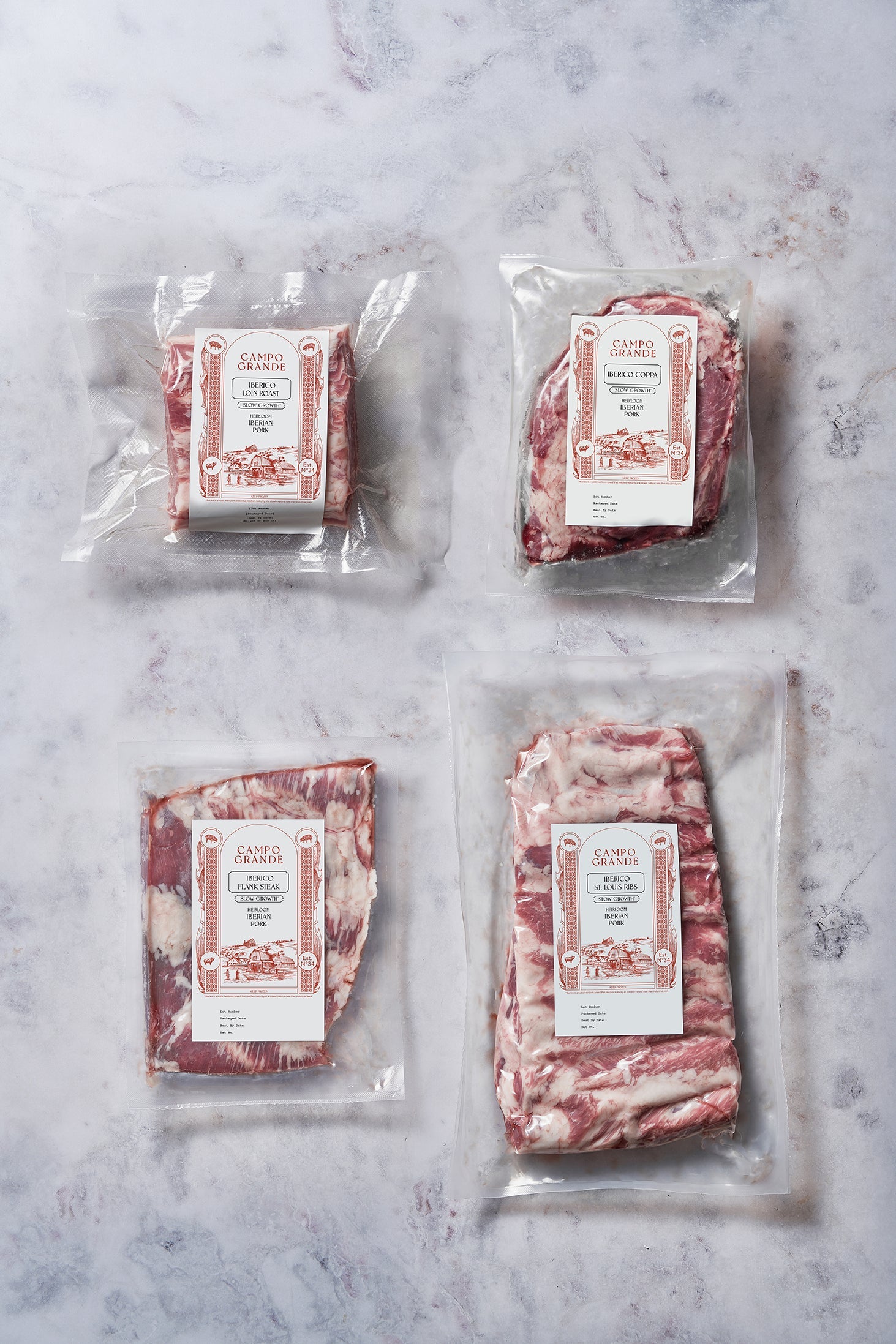 Four vacuum-sealed packages of raw beef cuts labeled Campo Grande on marble surface.
